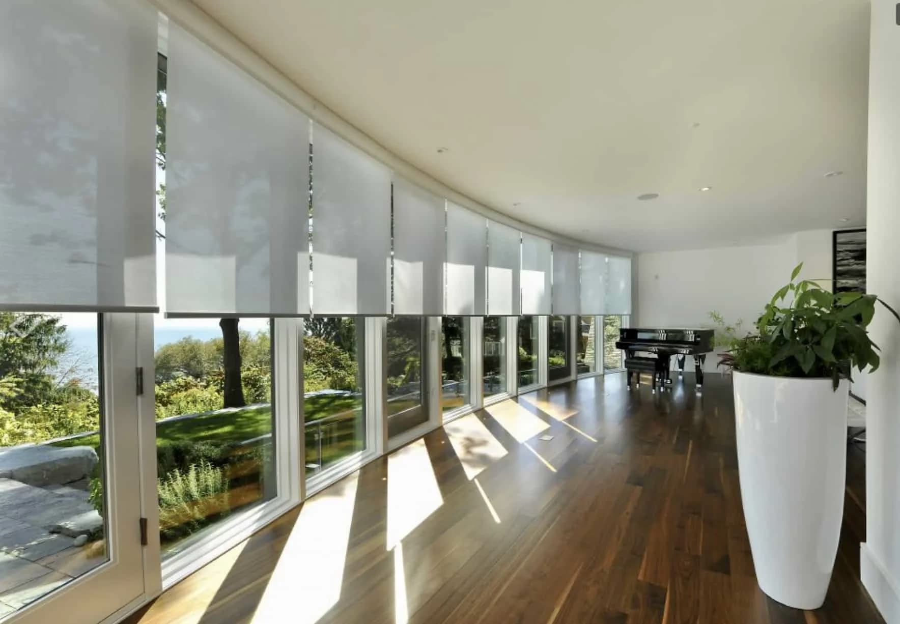 Curved sunroom with light-filtering roller shades