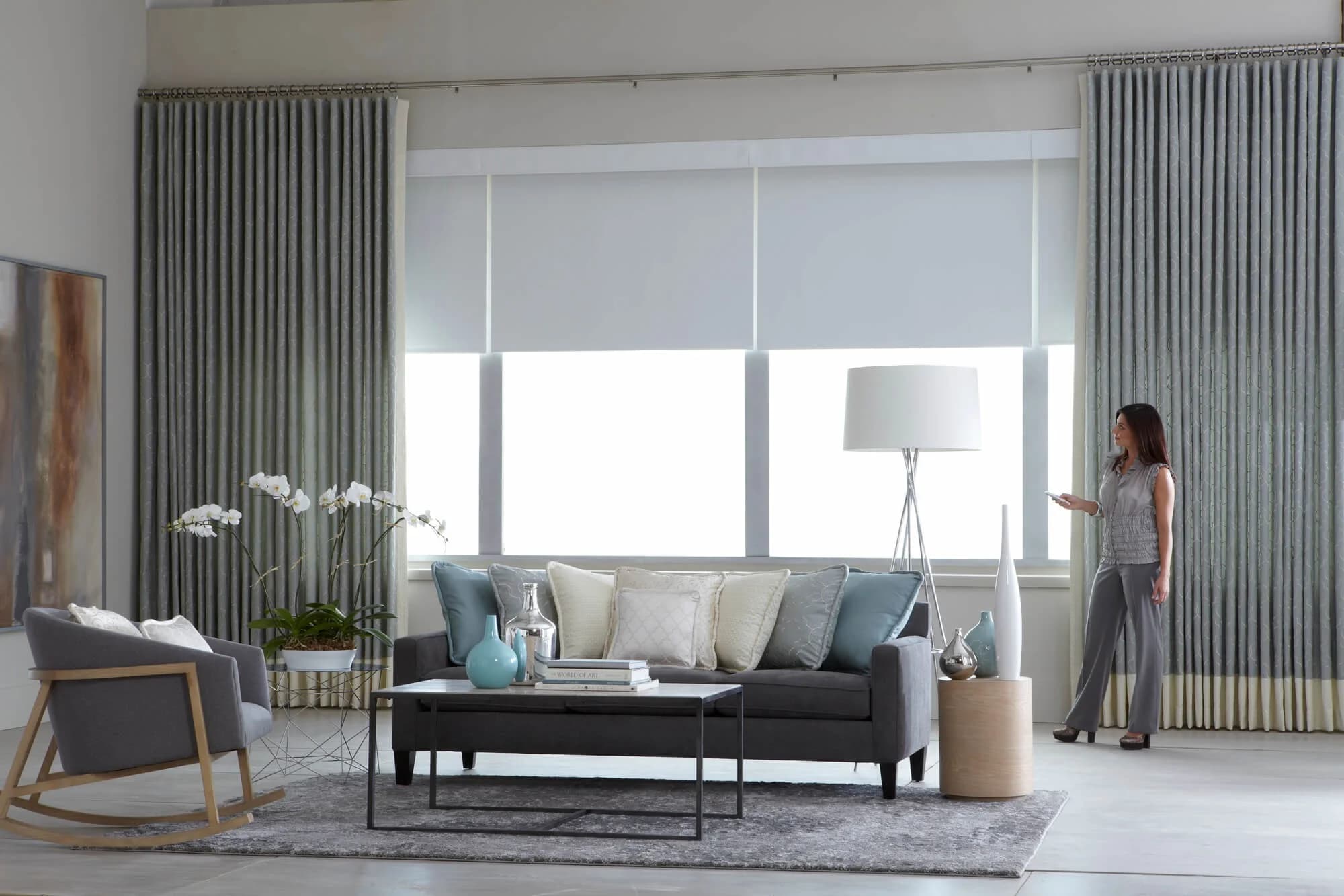 Elegant living room with motorized roller shades and drapes